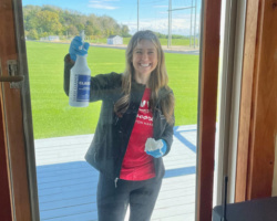 Volunteer cleaning the glass doors on the island before the 2021 camp season