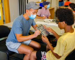 Mass Eye and Ear volunteer offers Camp Harbor View teen an eye test