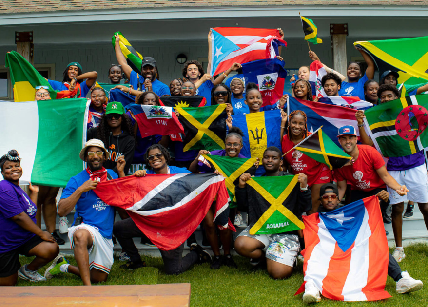 Group photo of teens and staff on the island holding flags