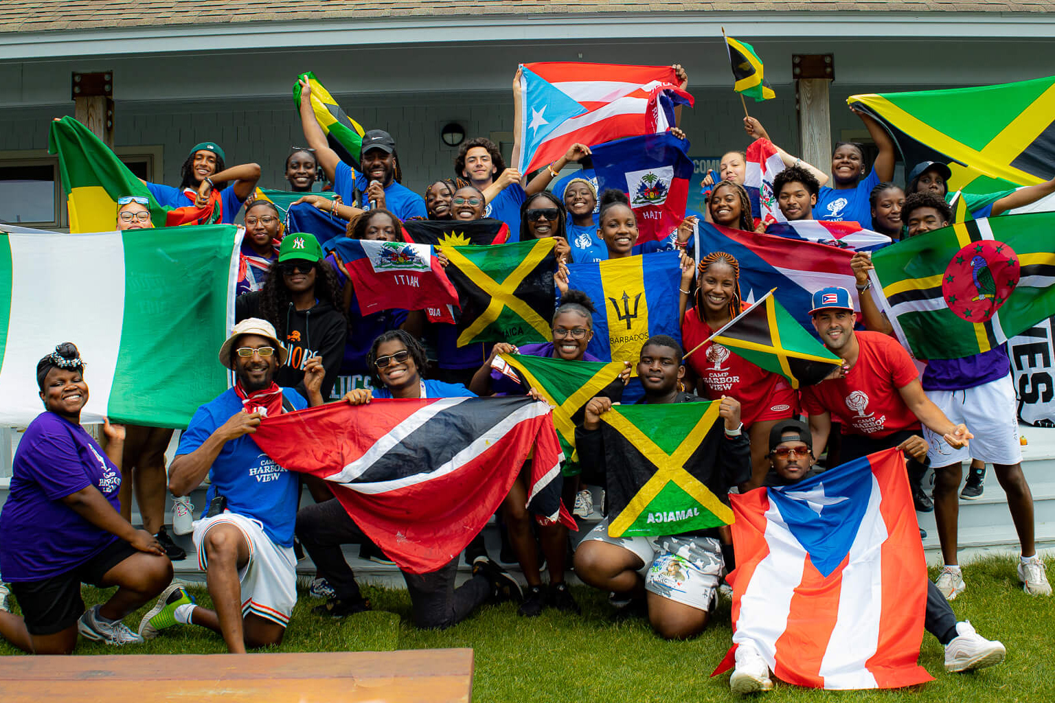 Group photo of teens and staff on the island holding flags