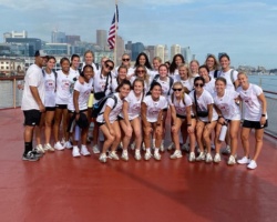 Boston College women's soccer team pose for photo on their way to volunteer at Camp Harbor View